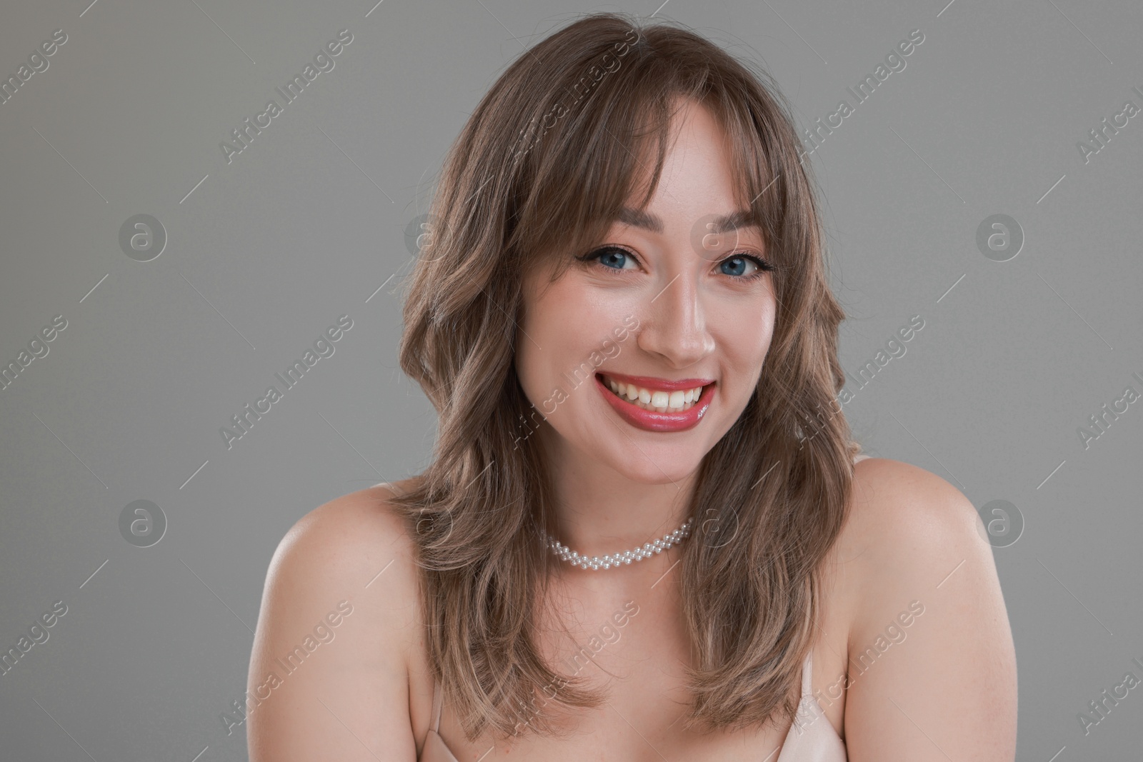 Photo of Attractive woman with stylish haircut on grey background