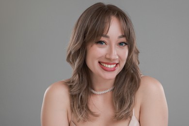 Photo of Attractive woman with stylish haircut on grey background