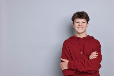 Photo of Portrait of happy teenage boy on light grey background, space for text