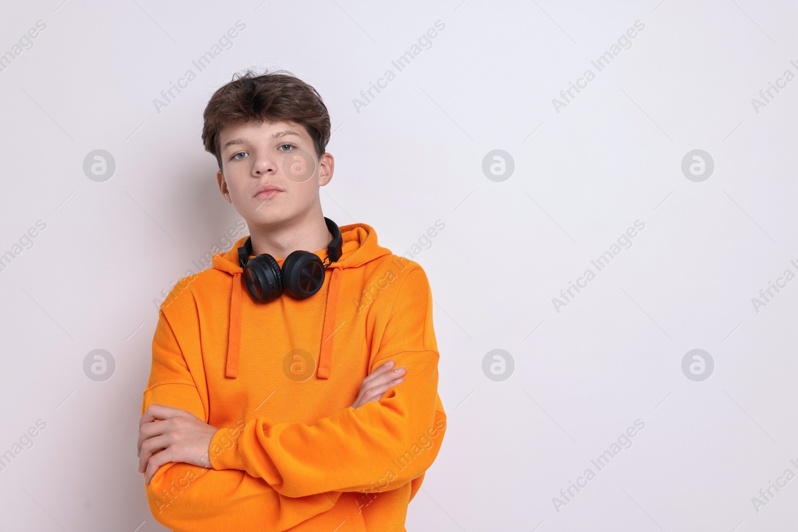 Photo of Teenage boy with headphones on white background, space for text