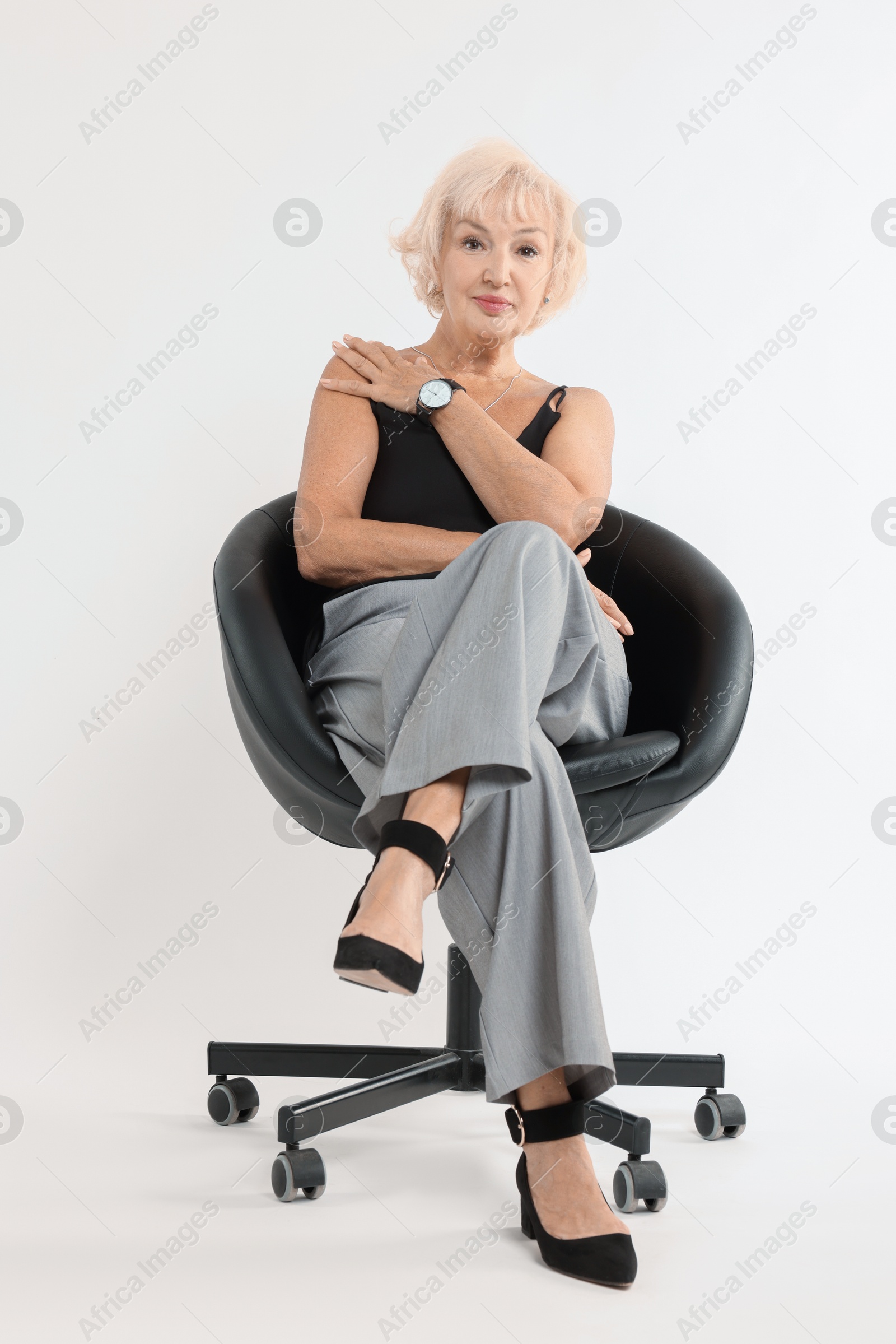 Photo of Beautiful senior woman sitting on chair against white background