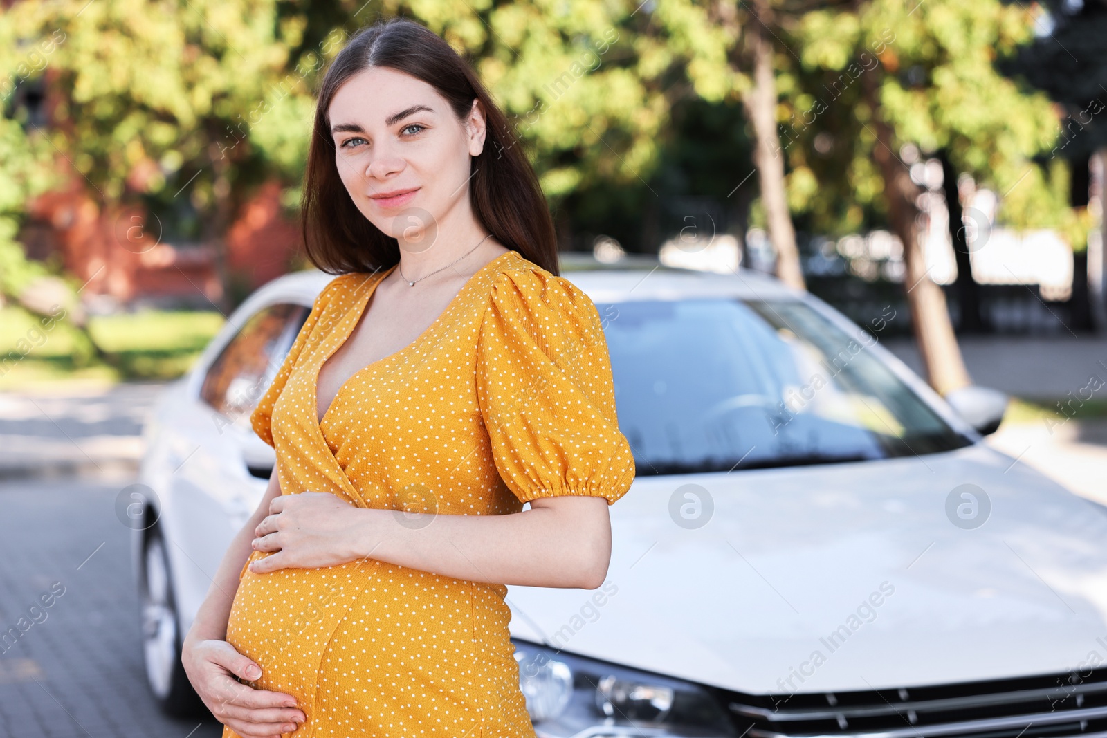 Photo of Portrait of beautiful pregnant woman near car outdoors