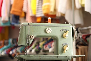 Photo of Vintage sewing machine with thread in workshop