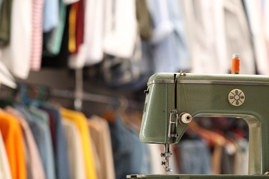 Photo of Vintage sewing machine with thread in workshop. Space for text