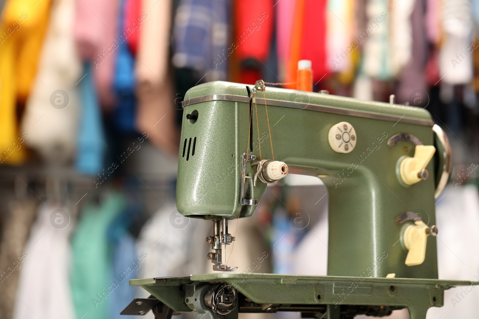 Photo of Vintage sewing machine with thread in workshop