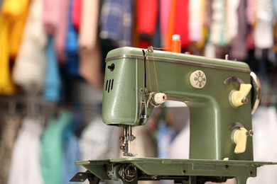 Photo of Vintage sewing machine with thread in workshop