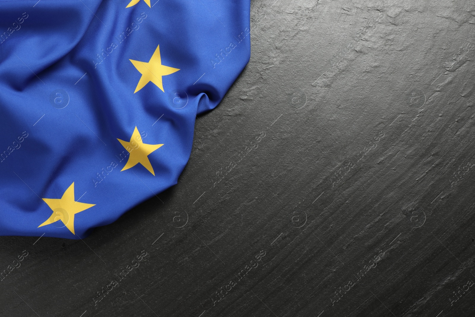 Photo of Flag of European Union on black textured background, top view. Space for text