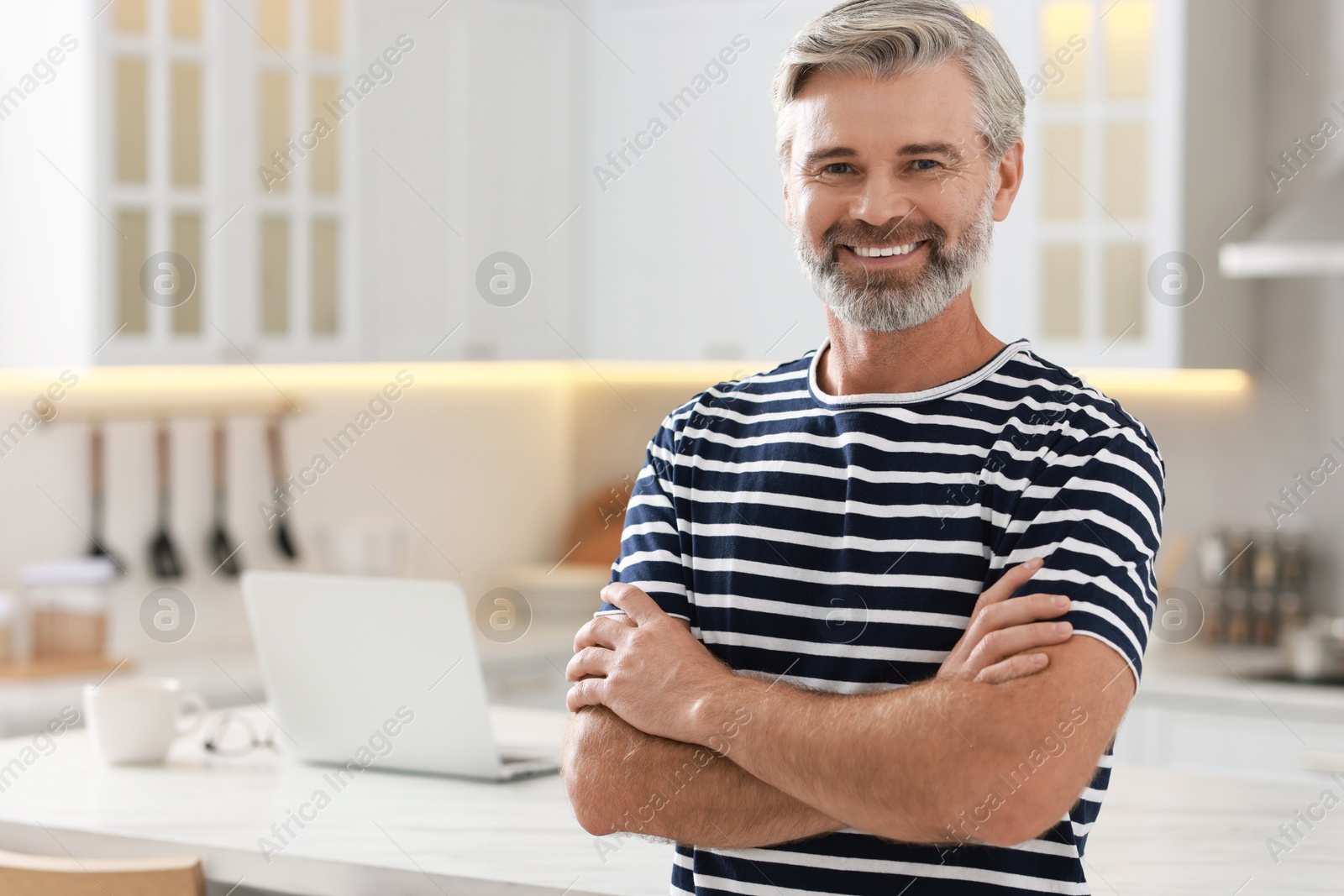 Photo of Portrait of happy middle aged man in kitchen, space for text