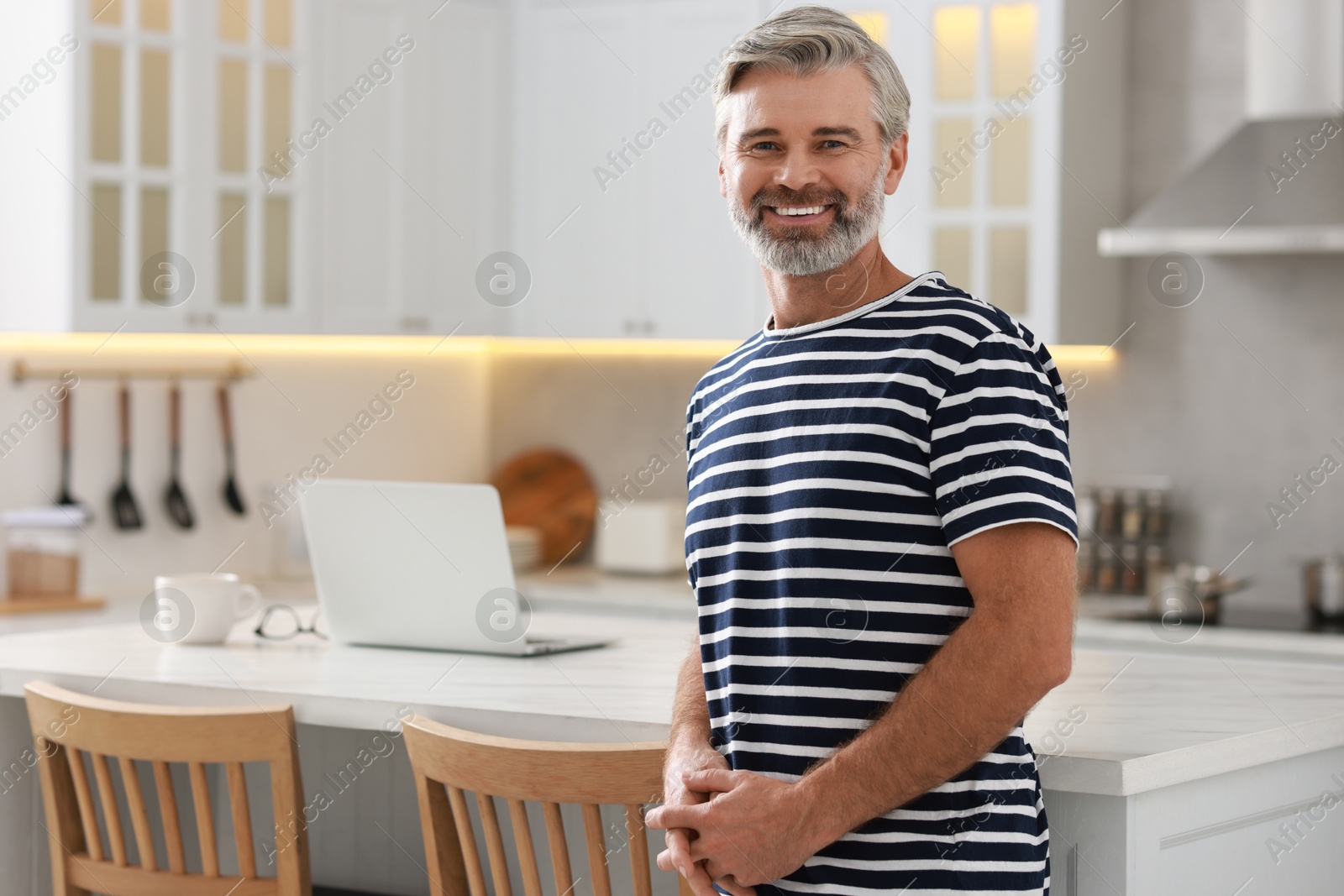 Photo of Portrait of happy middle aged man in kitchen, space for text