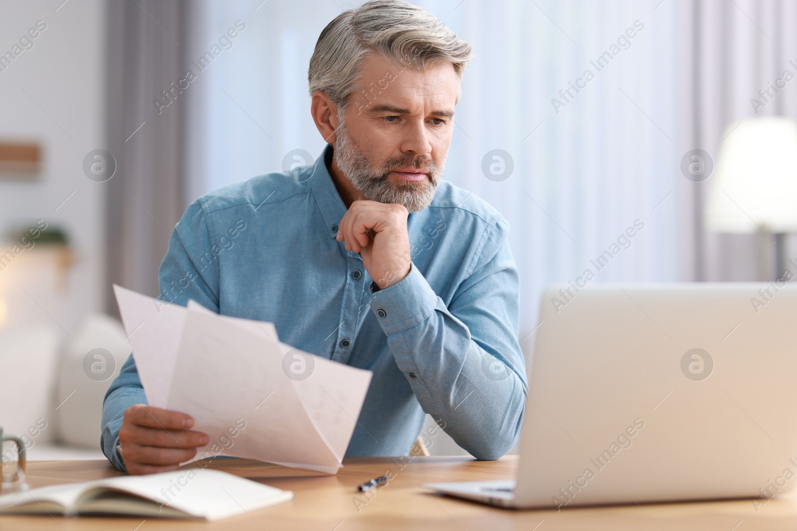 Photo of Middle aged man working at table indoors