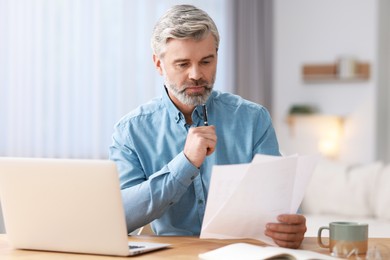 Photo of Middle aged man working at table indoors