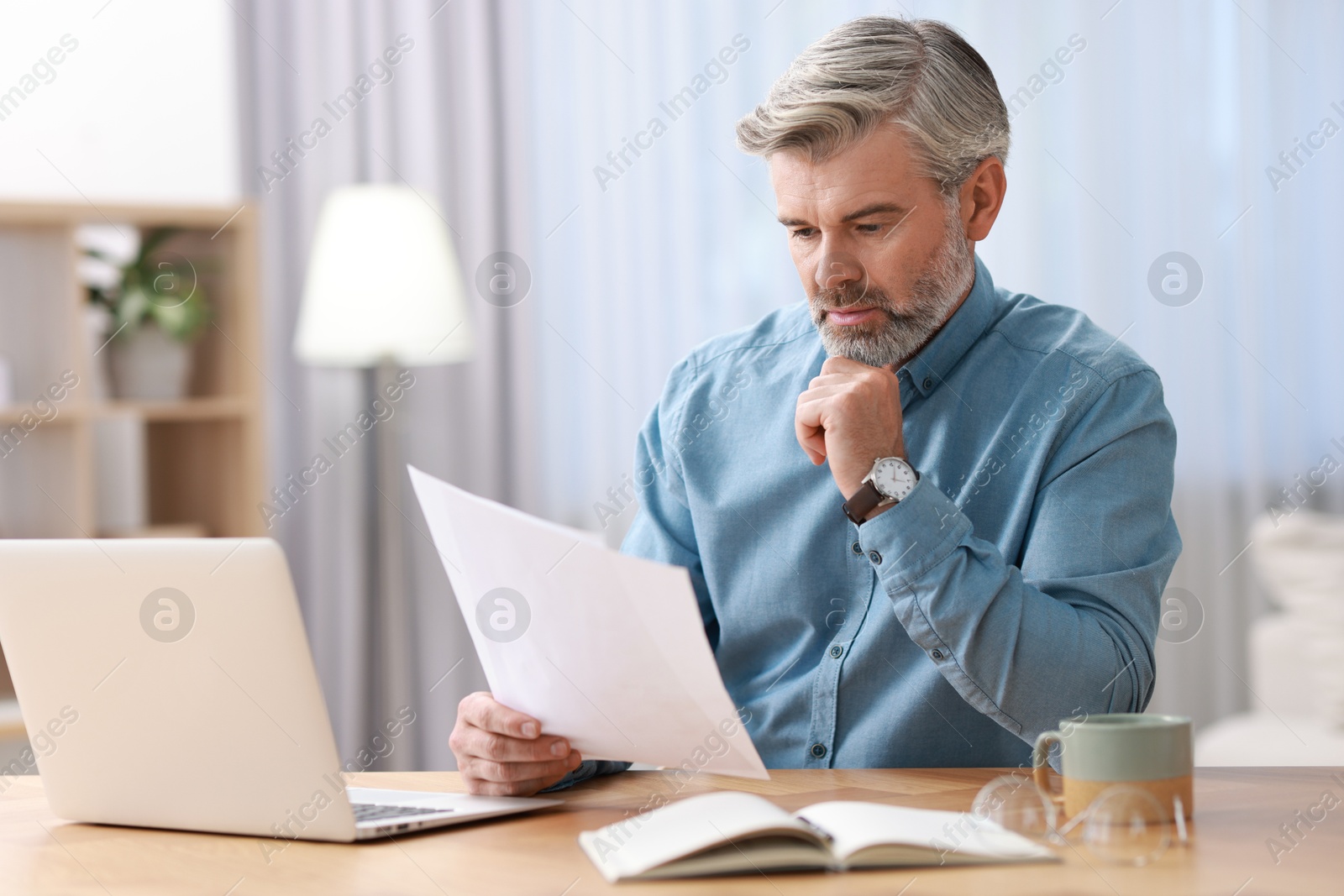 Photo of Middle aged man working at table indoors