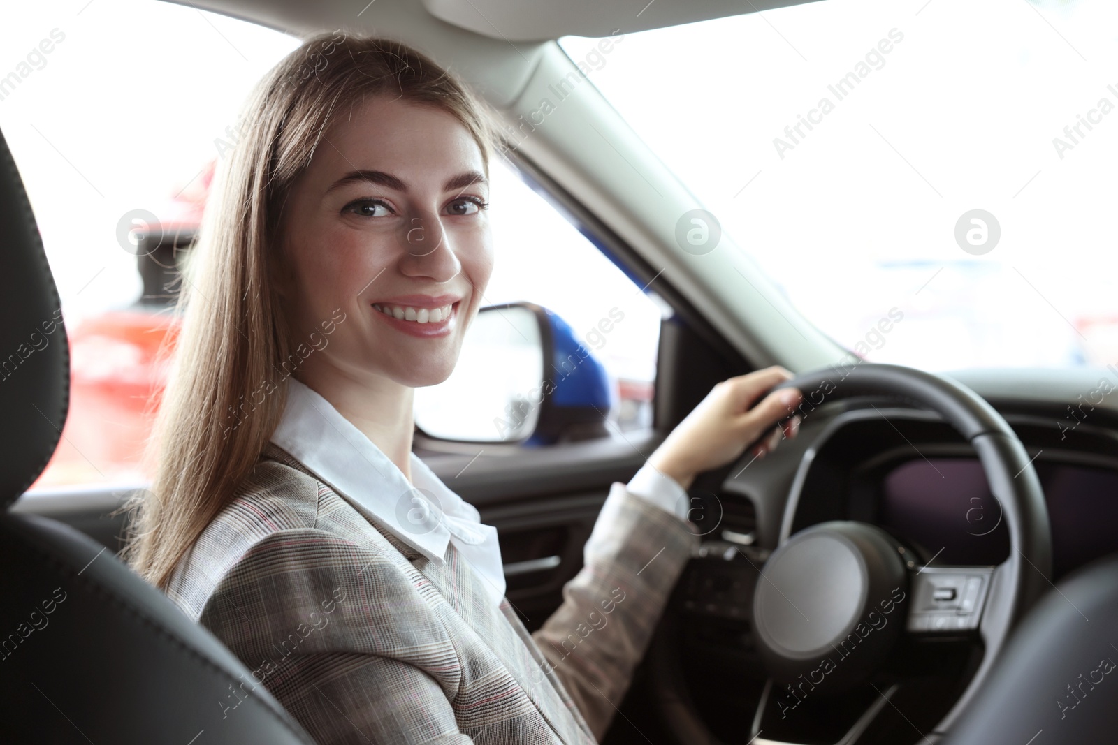 Photo of Young woman inside new car in salon