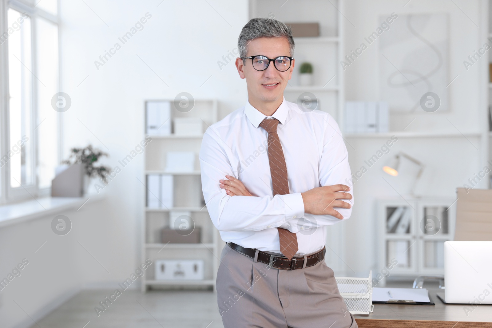 Photo of Portrait of middle aged man with crossed arms in office