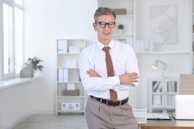 Photo of Portrait of middle aged man with crossed arms in office