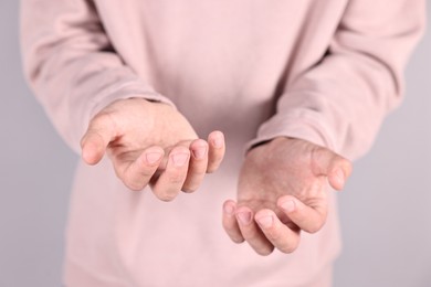 Photo of Man holding something on grey background, closeup