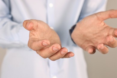 Photo of Man holding something on grey background, closeup