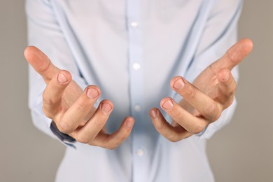 Man holding something on grey background, closeup