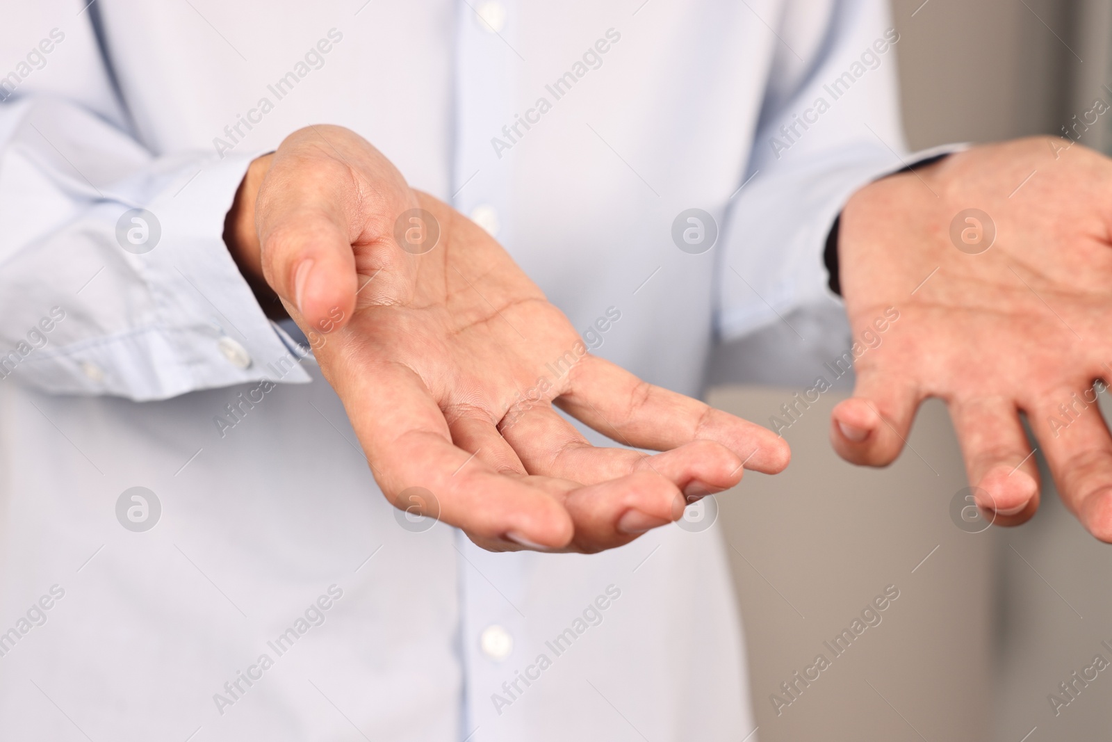 Photo of Man holding something on grey background, closeup