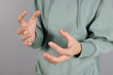 Photo of Man holding something on grey background, closeup