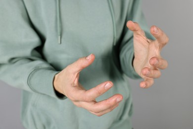 Photo of Man holding something on grey background, closeup