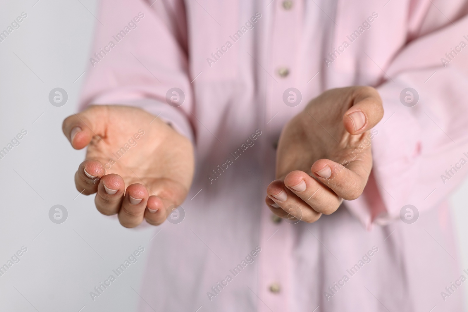 Photo of Man holding something on light background, closeup