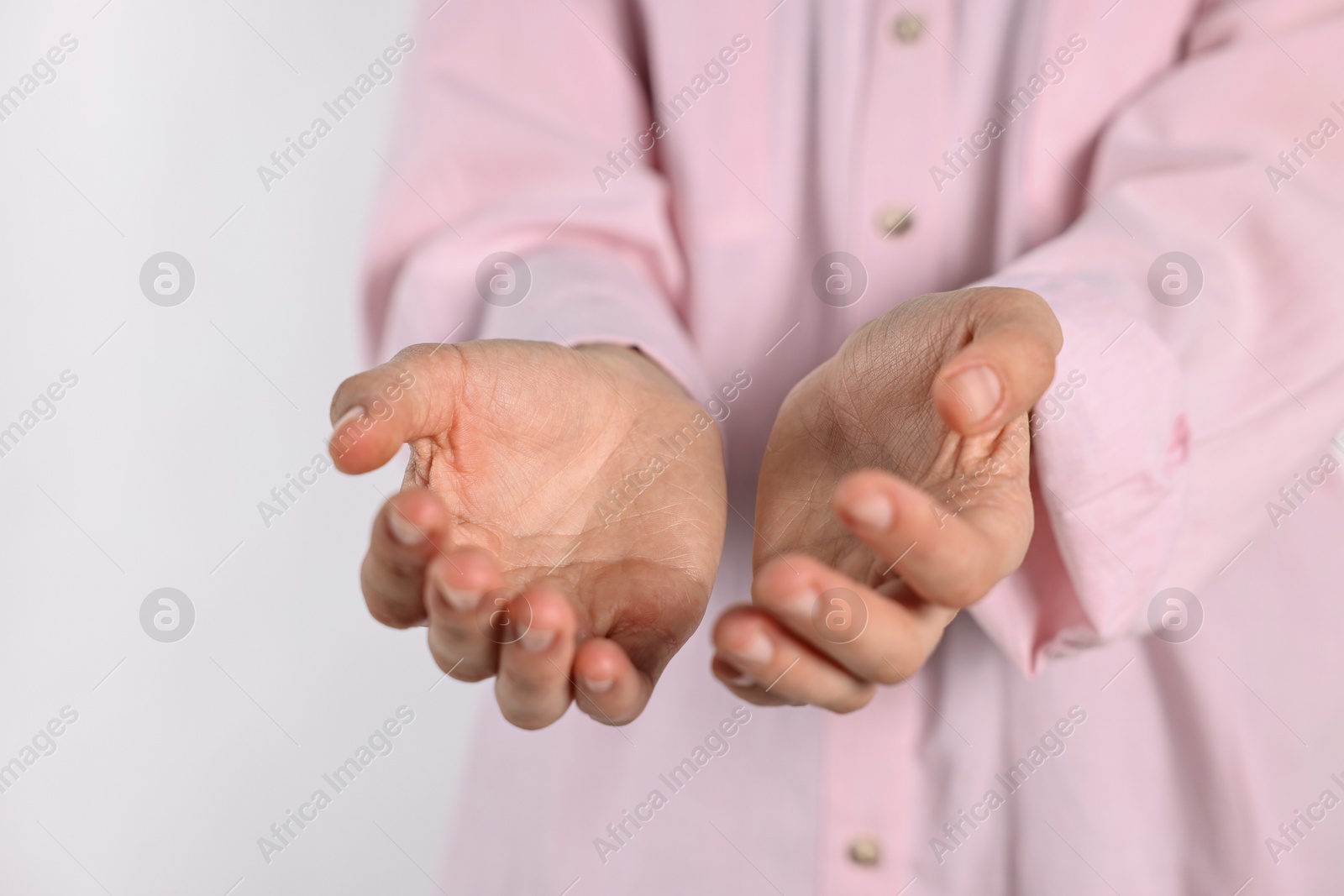 Photo of Man holding something on light background, closeup