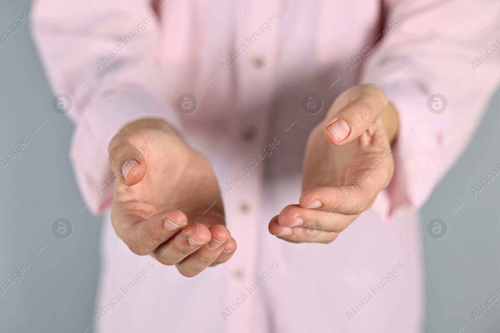 Photo of Man holding something on grey background, closeup