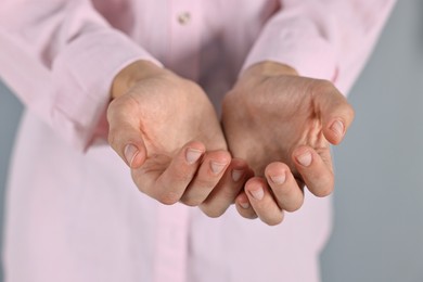 Photo of Man holding something on grey background, closeup