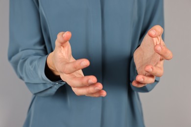 Photo of Man holding something on grey background, closeup