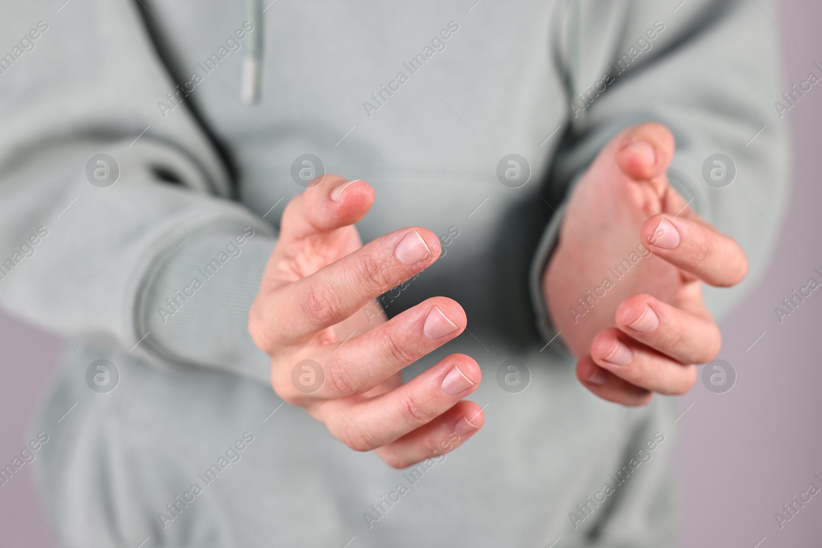 Photo of Man holding something on grey background, closeup