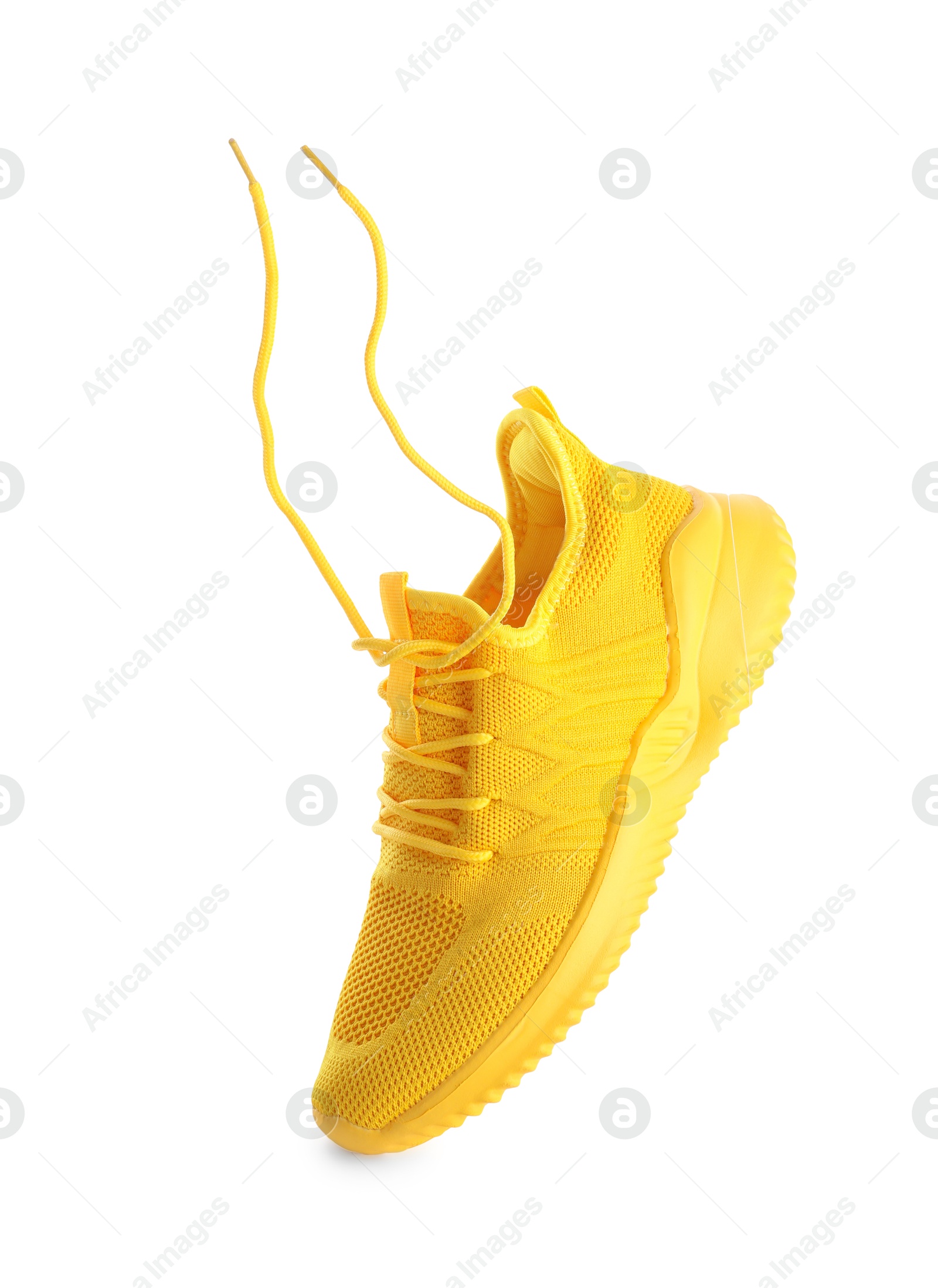 Photo of One stylish yellow sneaker isolated on white