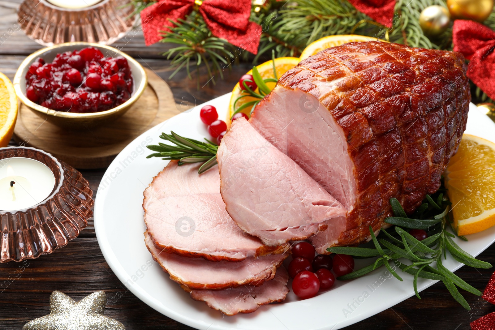 Photo of Christmas food. Tasty baked ham served on wooden table, closeup