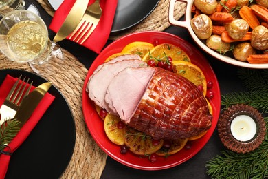 Tasty baked ham served on black wooden table, flat lay