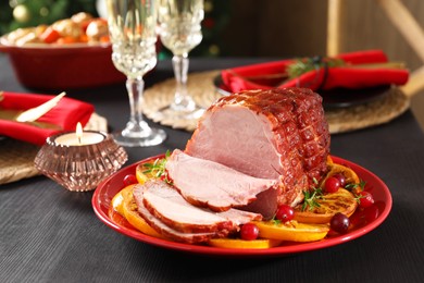 Photo of Tasty baked ham served on black wooden table, closeup