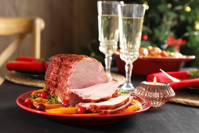 Photo of Tasty baked ham served on black wooden table, closeup