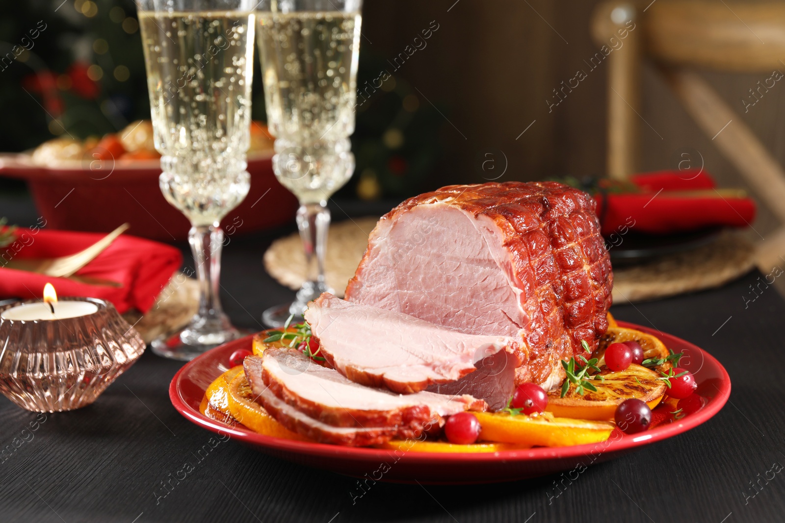 Photo of Tasty baked ham served on black wooden table, closeup