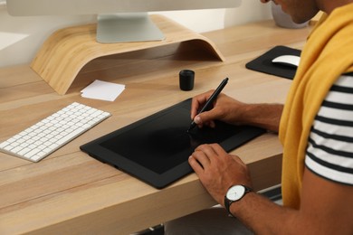 Photo of Professional retoucher working on graphic tablet at desk, closeup