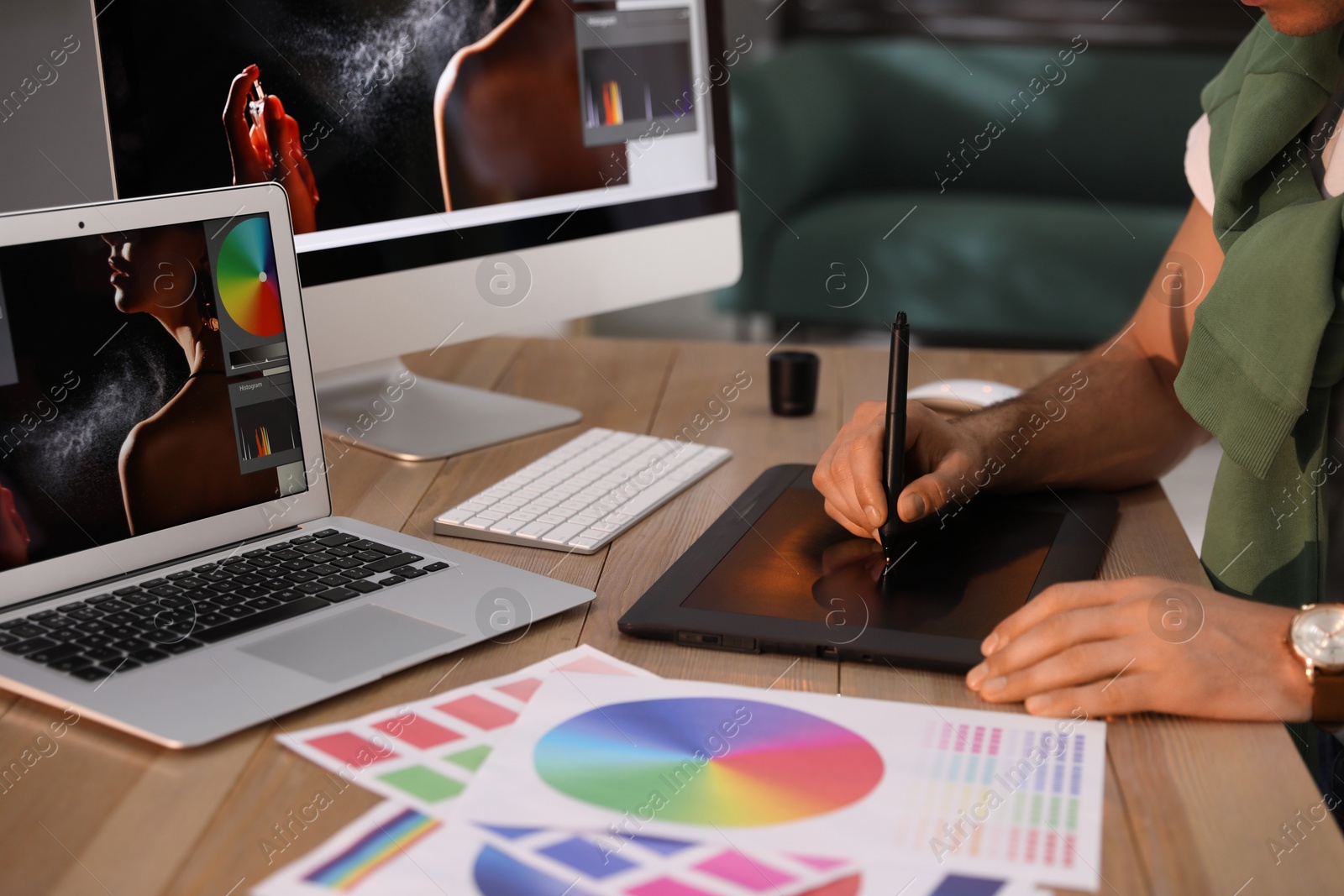 Photo of Professional retoucher working on graphic tablet at table, closeup