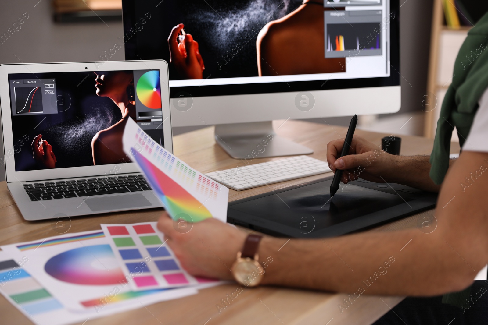 Photo of Professional retoucher working on graphic tablet at table, closeup