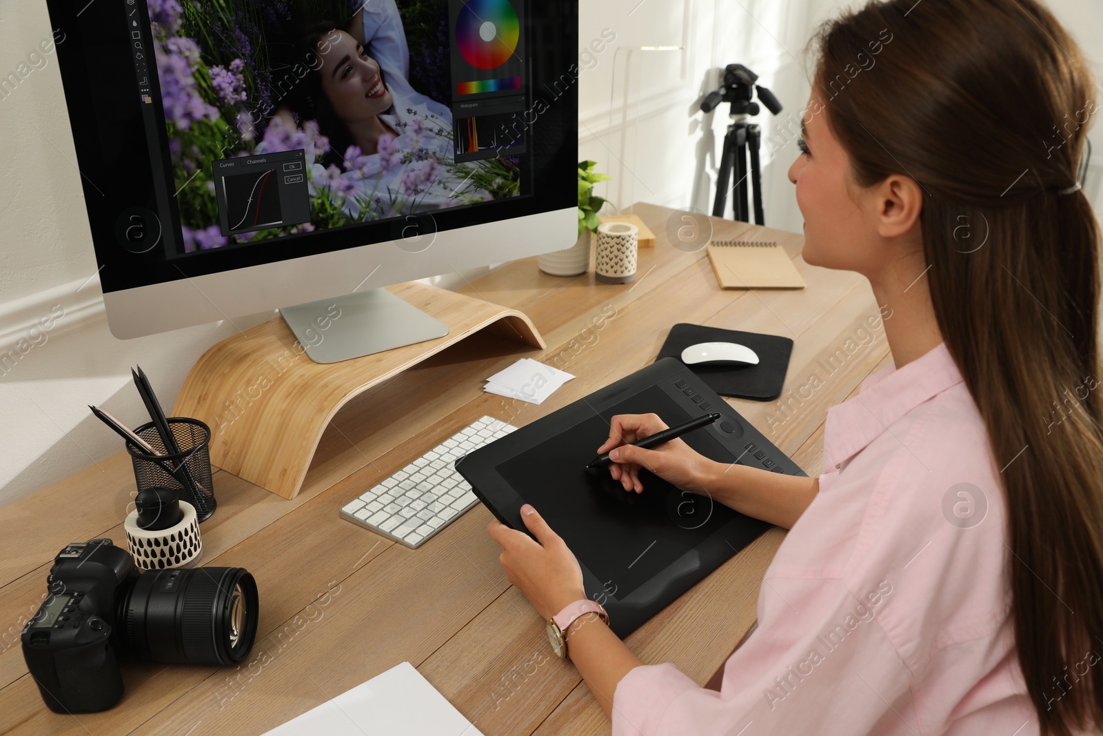 Photo of Professional retoucher working on graphic tablet at desk in office