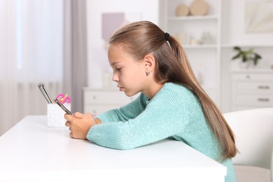 Photo of Girl with incorrect posture using smartphone at white desk indoors