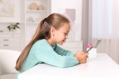 Photo of Girl with incorrect posture using smartphone at white desk indoors