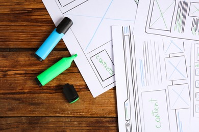 Photo of Developing UI design. Sketches of website wireframes and felt pens on wooden table, top view