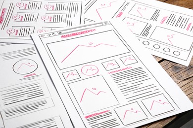 Developing UI design. Sketches of website wireframes on wooden table, closeup