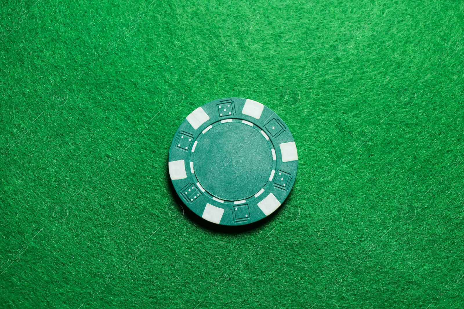 Photo of Poker chip on green table, top view