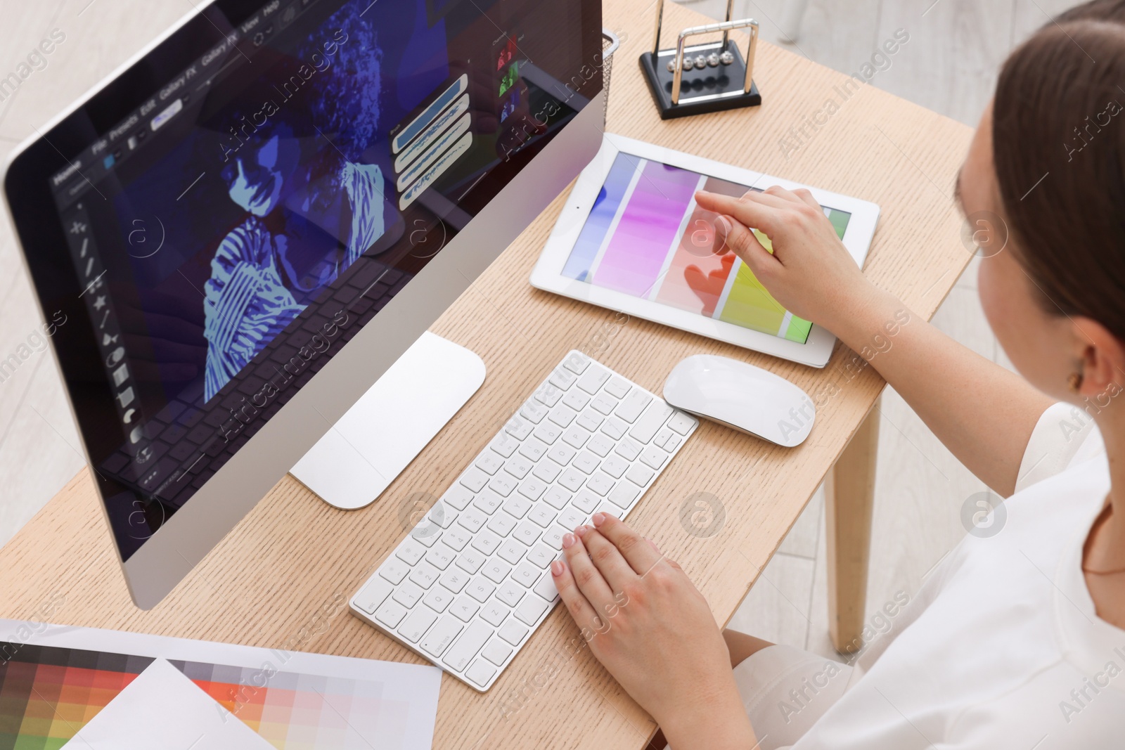 Photo of Designer working on computer at wooden table