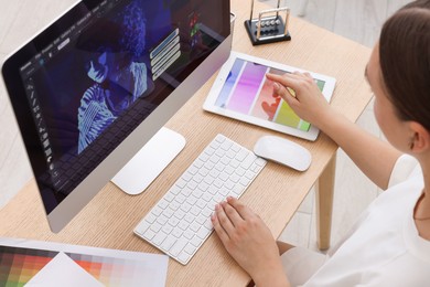 Photo of Designer working on computer at wooden table