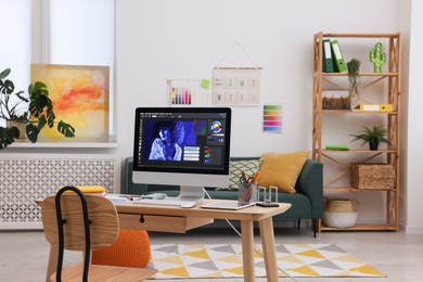 Photo of Designer's workplace with computer and stationery on wooden table indoors