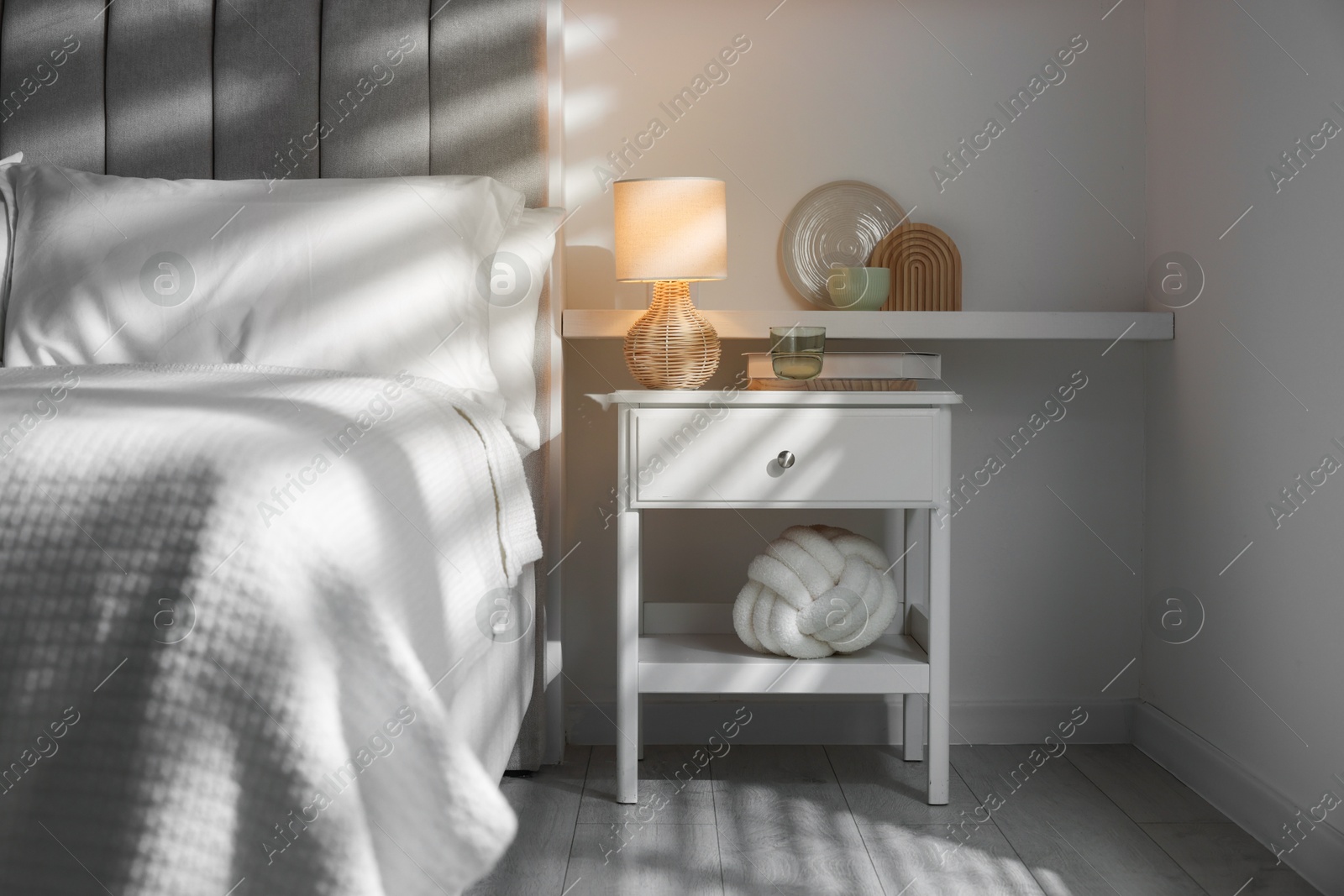 Photo of Stylish living room interior with bed, bedside table and lamp